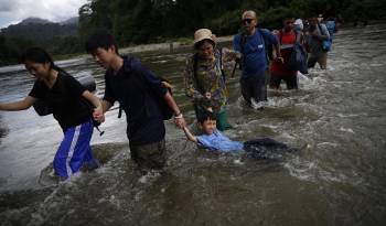 Migrantes cruzan el río Turquesa en Darién, en una fotografía de archivo.