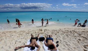 Fotografía de archivo que muestra a los turistas mientras descansan en una playa, del balneario de Cancún, en Quintana Roo, México.