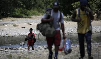 Personas migrantes cruzan el río Tuquesa en Darién (Panamá), en una fotografía de archivos.