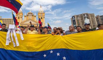 Manifestantes sostienen banderas durante una protesta convocada por María Corina Machado este miércoles, frente a la Basílica de nuestra señora de Chiquinquirá, en Maracaibo.