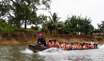 Fotografía del 8 de octubre de 2024 de migrantes transportándose en una lancha por el rio Turquesa desde el pueblo de Bajo Chiquito al centro de recepción migratoria de Lajas Blancas.