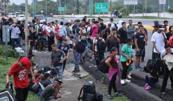 Migrantes caminan en caravana este viernes en el municipio de Tapachula en Chiapas.