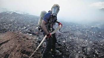 Imagen de personal idóneo sofocando uno de los incendios en el vertedero.