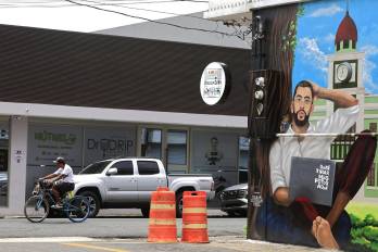 Una persona pasa en bicicleta frente a un mural de Bad Bunny.