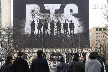 Seúl, 20/03/2026.- Varias personas caminan cerca del escenario principal para presenciar un concierto gratuito del grupo de K-pop BTS en la plaza Gwanghwamun de Seúl.