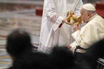 El papa besa una estatua del Niño Jesús durante la celebración de la Epifanía.