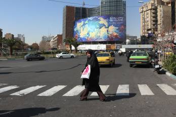 TEHRAN (IRAN(Islamic Republic Of)), 21/02/2026.- Iranians walk past a huge billboard carrying a poem interpretation in Persian 'Human will defeat the evils' at Valiasr Square in Tehran, Iran, 21 February 2026. As tension between Iran and US continue, US President Donald Trump said that he would wait for 10 to 15 days to reach a deal with the Iranian government. (Teherán) EFE/EPA/ABEDIN TAHERKENAREH