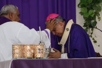 El padre Rafael Siu impone las cenizas al arzobispo de Panamá.