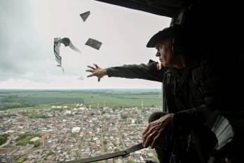 Fotografía de archivo que muestra a un oficial de la Policía lanzando volantes informativos desde un helicóptero en la región colombiana de Urabá en una campaña para invitar a la comunidad a denunciar la ubicación de los jefes del Clan del Golfo.