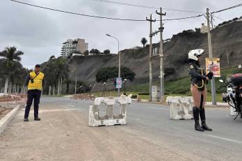 Integrantes de equipos de seguridad cierran la avenida Costa Verde por derrumbes en el acantilado, producto del sismo ocurrido este domingo, en Lima (Perú).