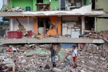 Dos residentes entre los escombros de uno de los bloques de viviendas derrumbado por los terremotos en la localidad de Catia La Mar, en el estado costero de La Guaira.