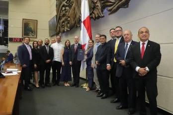 El ministro de Economía y Finanzas, Felipe Chapman (centro), recibe el documento del Presupuesto 2027 aprobado en tercer debate por la presidenta de la Asamblea Nacional, Shirley Castañedas (derecha), junto a diputados del Pleno.