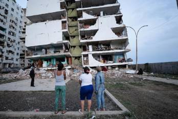 Residentes observan varios bloques de viviendas dañados por los terremotos en la localidad de Catia La Mar, en el estado costero de La Guaira.