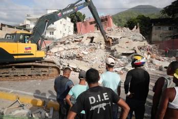 Una retroexcavadora trabaja en una zona afectada por los terremotos en La Guaira.