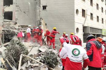 Fotografía cedida por el servicio de emergencias de la Media Luna Roja iraní que muestran el rescate de heridos en el bombardeo de un edificio en la capital del país, este lunes.