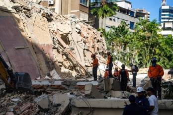 Integrantes de la Defensa Civil de Venezuela participan este jueves, en las labores de remoción de escombros y búsqueda de sobrevivientes entre edificios colapsados por los terremotos.