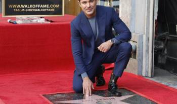 El actor estadounidense Zac Efron posa sobre su recién presentada estrella en el Paseo de la Fama de Hollywood durante una ceremonia en su honor en Los Ángeles (California, EE.UU.) el 11 de diciembre de 2023.