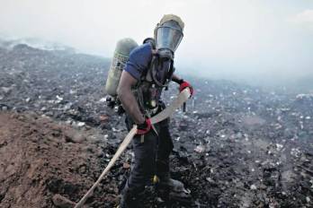 Imagen de personal idóneo sofocando uno de los incendios en el vertedero.