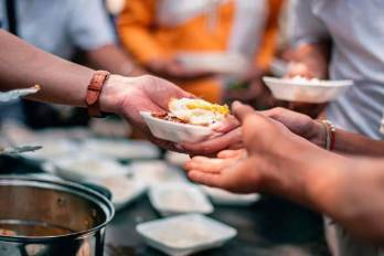 Voluntarios dan comida a personas que carecen de alimentos.