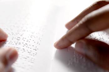 Black hands are reading braille