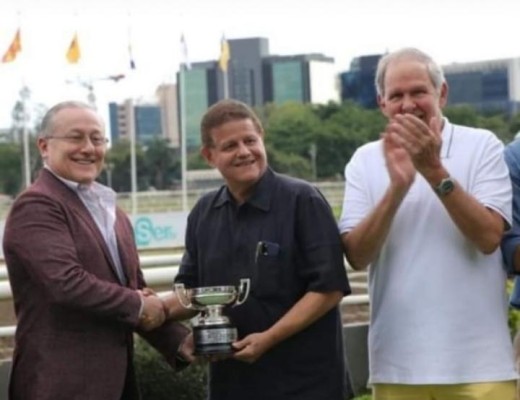 Eric Antonio Delvalle (i) entrega la copa del triunfo a Luis Ramón Arias, en representación del Fair Grounds Stable.