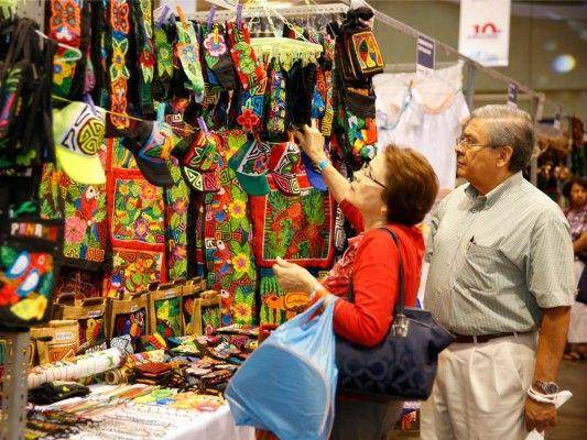 Imagen de archivo donde asistentes a la Feria Nacional de Artesanías admiran las molas elaboradas por las mujeres de la Comarca Guna Yala.