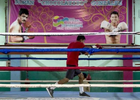 Un joven practica boxeo frente a una pared con la imagen del boxeador Román “Chocolatito” González (d) en el gimnasio de boxeo Roger Deshon, hoy, en Managua. |