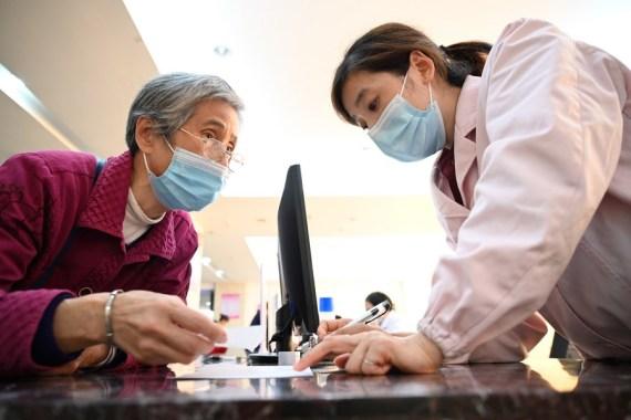 Imagen de archivo donde una empleada explica las políticas de seguro médico a una residente en un hospital en Sanming, en la provincia de Fujian.