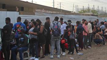 Migrantes hacen fila para ingresar al 'Centro Multiservicios' en Tapachula (México).