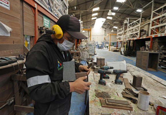 Trabajadores de la Asociación de Recicladores de Bogotá (ARB) diseñan objetas con madera plástica fabricada por la organización