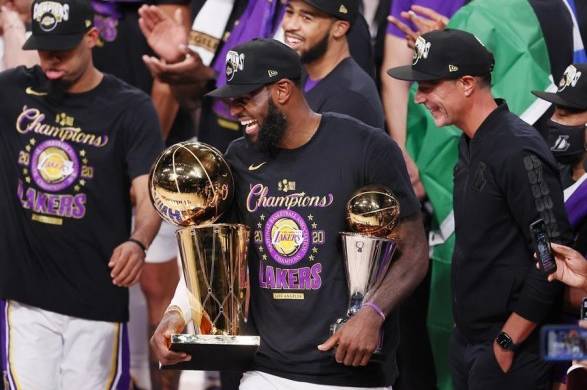 El jugador de los Lakers de Los Ángeles LeBron James (c) festeja con el trofeo Larry O'Brien