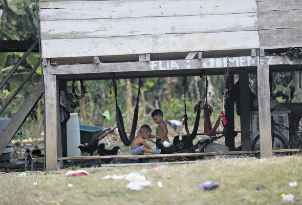 Dos niños juegan debajo de una casa de estilo colonial, ubicada en El Real de Santa María.