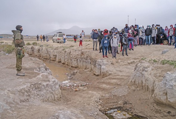 Un grupo de migrantes de nacionalidades chilena, boliviana y venezolana espera para cruzar de Bolivia a Chile, en una fotografía de archivo.