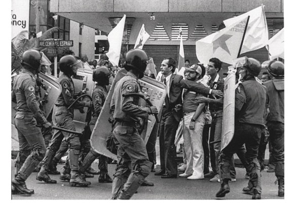 Ricardo Arias Calderón protege a un grupo de manifestantes de las fuerzas antimotines.