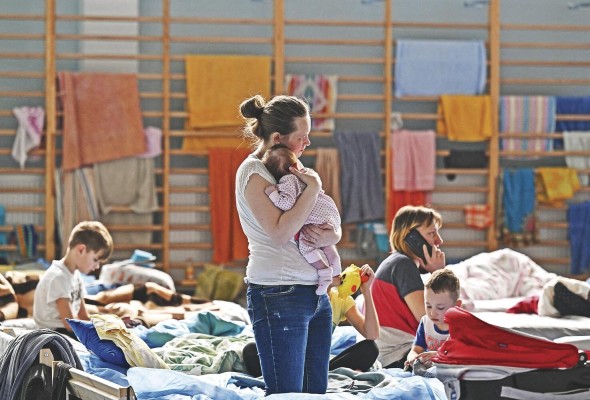 Una mujer sostiene a su bebé de dos meses en un refugio temporal ubicado en un gimnasio de una escuela secundaria en Przemysl, cerca de la frontera entre Ucrania y Polonia.