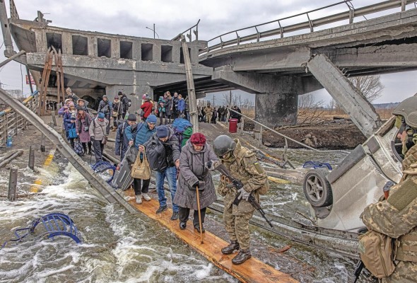 Decenas de civiles cruzaban por un puente semidestruido por los ataques rusos en la ciudad de Irpin, en la región ucraniana de Kiev, el pasado mes de marzo.