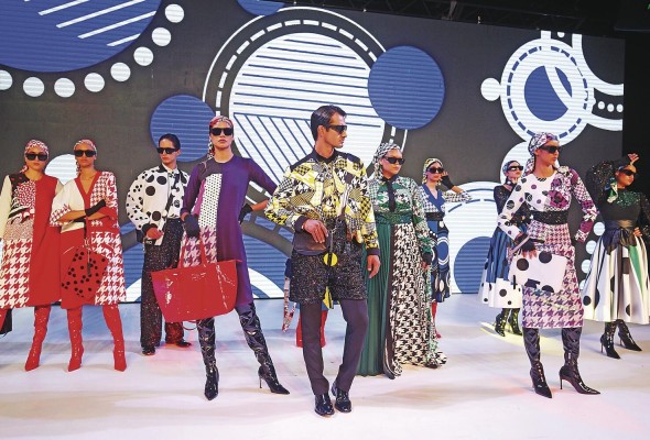 El diseñador creó vestidos rectos y amplios, faldas, blusas y sacos largos, además de pantalones y chaquetas para hombres con telas lisas pero que se confrontan con texturas de crepes, tornasoles lentejuelas y brillantes.