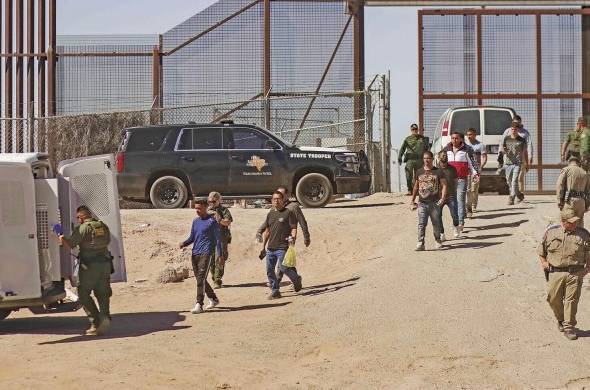 Fotografía general donde se observa a migrantes en un campamento junto al muro fronterizo en Tijuana, Baja California (México).