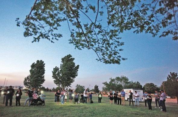 Varias personas participan en una vigilia en memoria de las víctimas del tiroteo en una escuela en Uvalde.