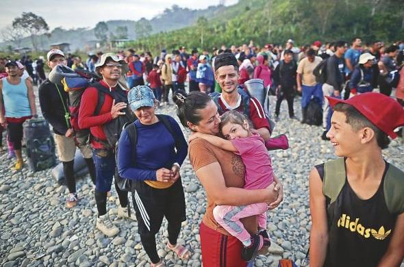 Adultos y niños migrantes hacen fila en la comunidad de Bajo Chiquito para ser trasladados a la Estación de Recepción Migratoria (ERM) de San Vicente.