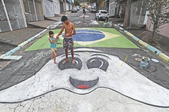 Los brasileños pintan una calle con los colores verde y amarillo.