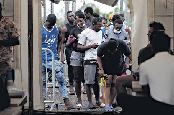 Migrantes hacen fila para registrarse en el albergue de San Vicente en Darién