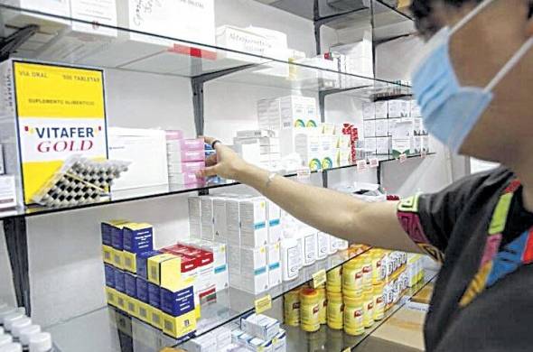 Una trabajadora despacha medicamentos en una farmacia.