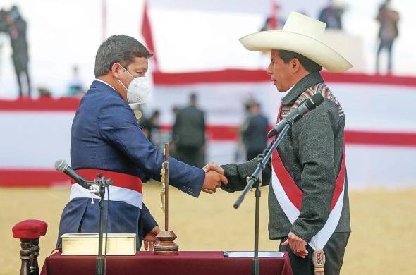 El recién investido presidente peruano Pedro Castillo (d), mientras celebra con Guido Bellido luego de elegirlo como primer ministro de su gobierno.