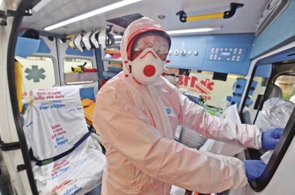 Trabajadores de la Cruz Blanca en Génova, Italia, se preparan con ropa de seguridad y mascarillas para recoger a sospechosos de contagio, el 13 de marzo.