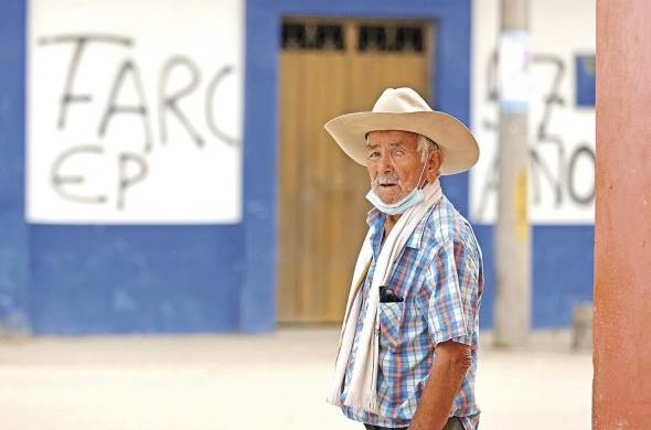 Fotografía de archivo del 19 de febrero de 2022 que muestra a un hombre frente a grafitis de las disidencias de las FARC, en Puerto Nariño (Colombia).