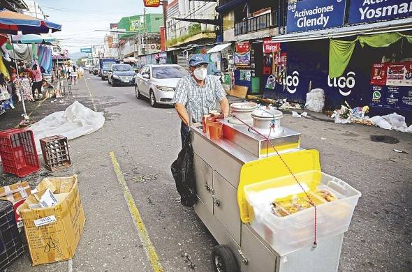 Un hombre con su carretón ambulante de venta de café se desplaza por la calle Rubén Darío en San Salvador, El Salvador.