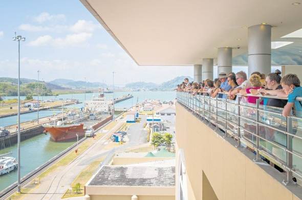 Un grupo de turistas observan la travesía de un buque en las esclusas del Canal de Panamá.