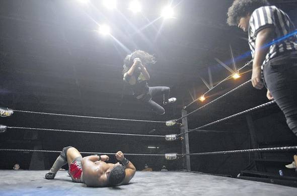 El luchador Deimos (arriba) se lanza contra Crush, durante una competencia de lucha libre, el 5 de noviembre de 2022, en Ciudad de Panamá