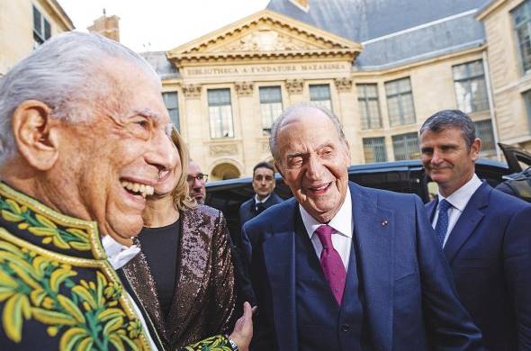 Mario Vargas Llosa (i) habla con el rey emérito Juan Carlos I (c) después de la ceremonia de su admisión.